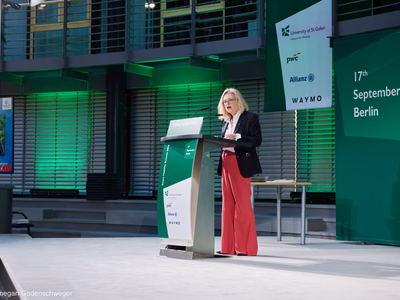 Ute Bonde, Schirmherrin der Mobility Trailblazers, spricht ihr Grußwort am Rednerpult auf der grün beleuchteten Bühne des Smart Mobility Summit 2026.